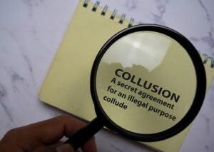 collusion written on notepad under magnifying glass